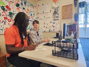 Julian talks to Moses about his internship at Pride Lands childcare