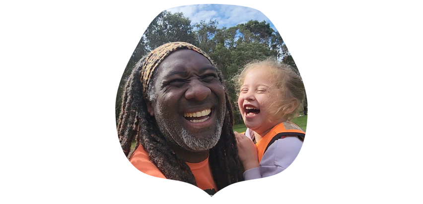 Photo of Moses, the founder of Pride Lands and Pre-schooler laughing at a childcare programme